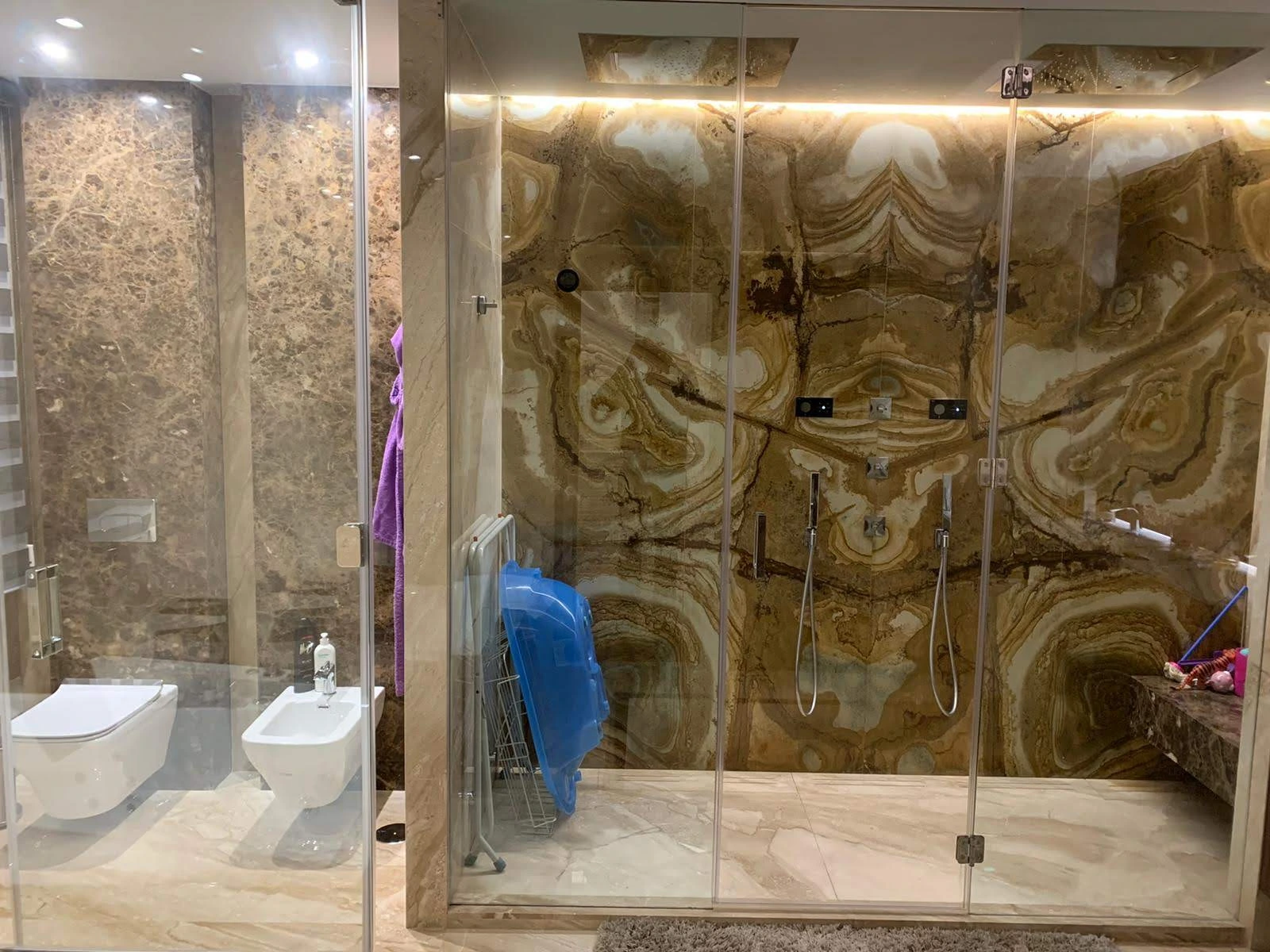 Baño con ducha de mármol dorado y vetas naturales - Ropema Rubio Madrid