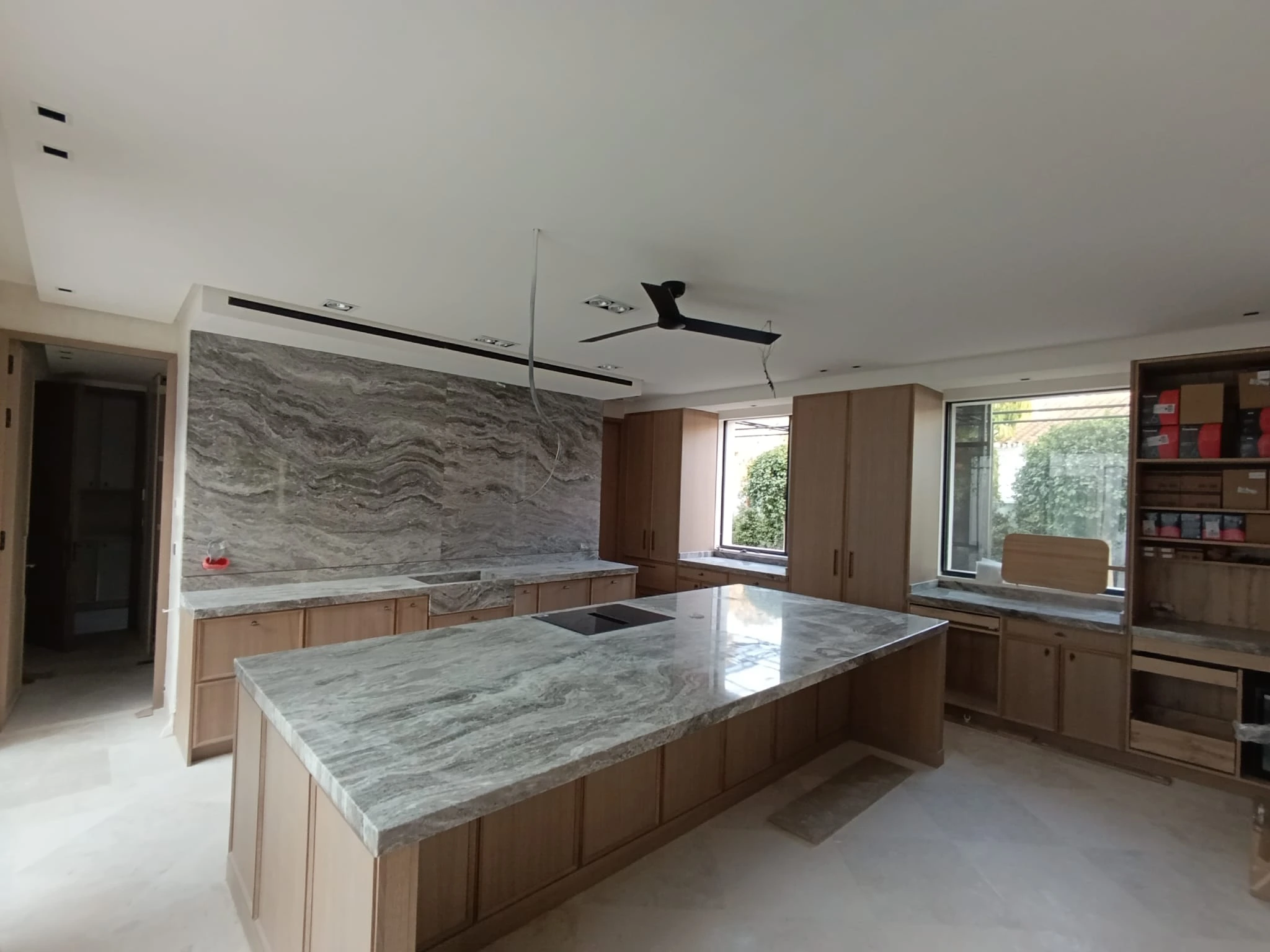 Cocina moderna con encimera de mármol gris veteado e isla central - Ropema Rubio Madrid