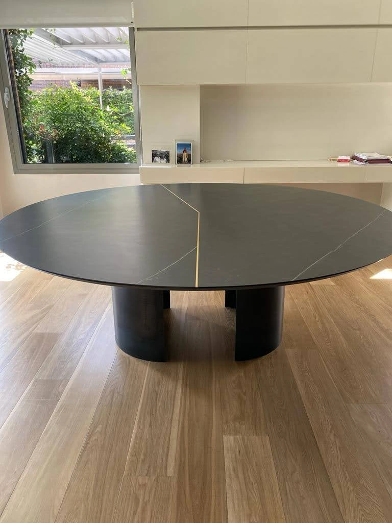 Mesa redonda de mármol negro con vetas doradas en comedor moderno - Ropema Rubio