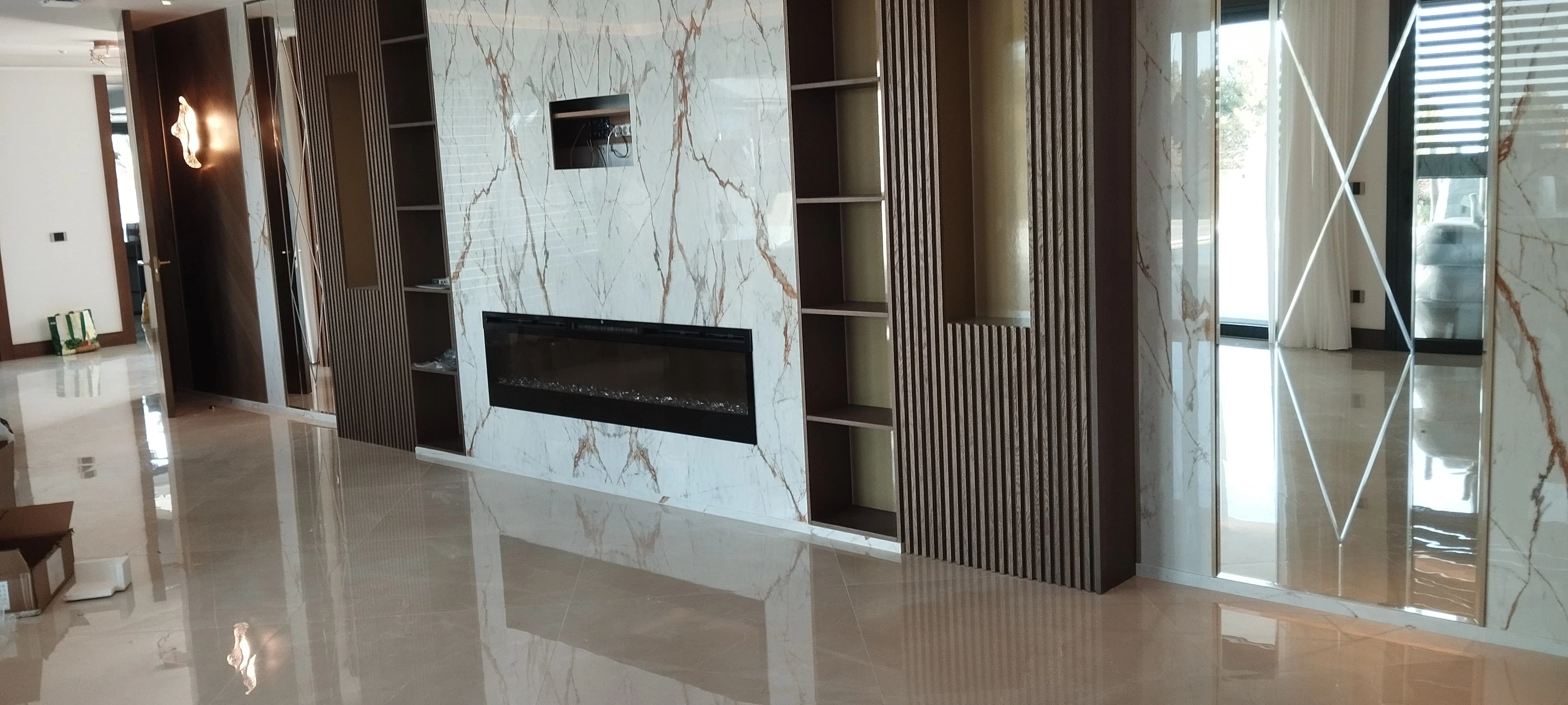 Salón moderno con chimenea y revestimiento de mármol blanco veteado - Ropema Rubio Madrid